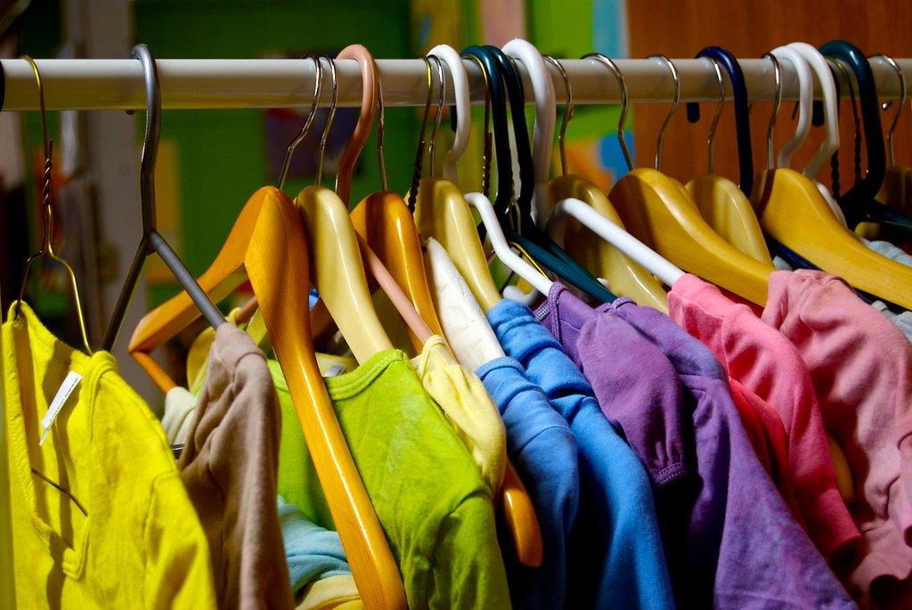 Percheros con ropa de colores en un local de indumentaria